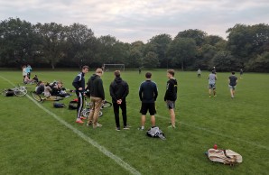 Junge Männer stehen auf einer Wiese und machen Pause vom Fußballspielen