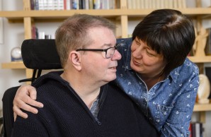 Tomas Gerlach und seine Frau lächeln sich an, sie legt den Arm um seine Schulter