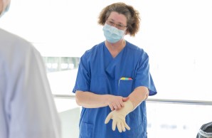 Sonja Biel zeigt während einer Hygieneschulung des Anlegen von Handschuhen