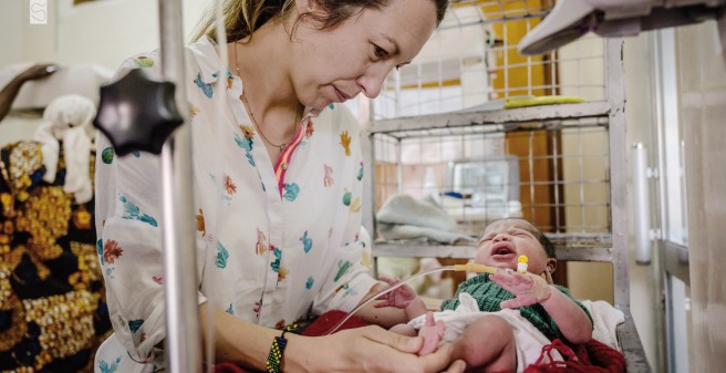 Dr. Harbauer hält den Fuß eines neugeborenen afrikanischen Kindes