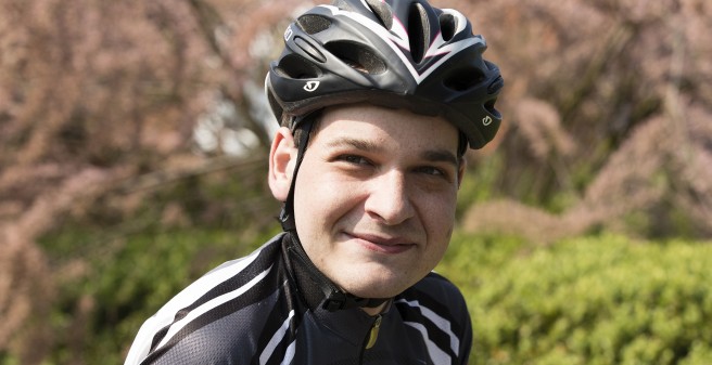 Simon Arndt mit Fahrradhelm, lächelt in die Kamera