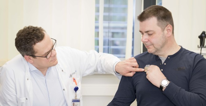 Dr. Arne Böttcher zeigt Thilo Schmidt die Stelle in der Nähe des linken Schlüsselbeins, wo der Schrifttmacher implantiert wurde
