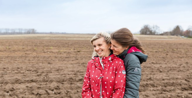 Sandra Fink und Schwester Doreen innig mit Blick auf ein weites Feld