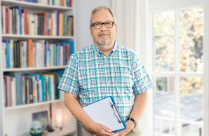 Dr. Frank Schulz- Kindermann steht vor einem Bücherregal