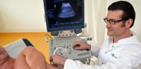 Arzt untersucht Patient mit Ultraschallgerät